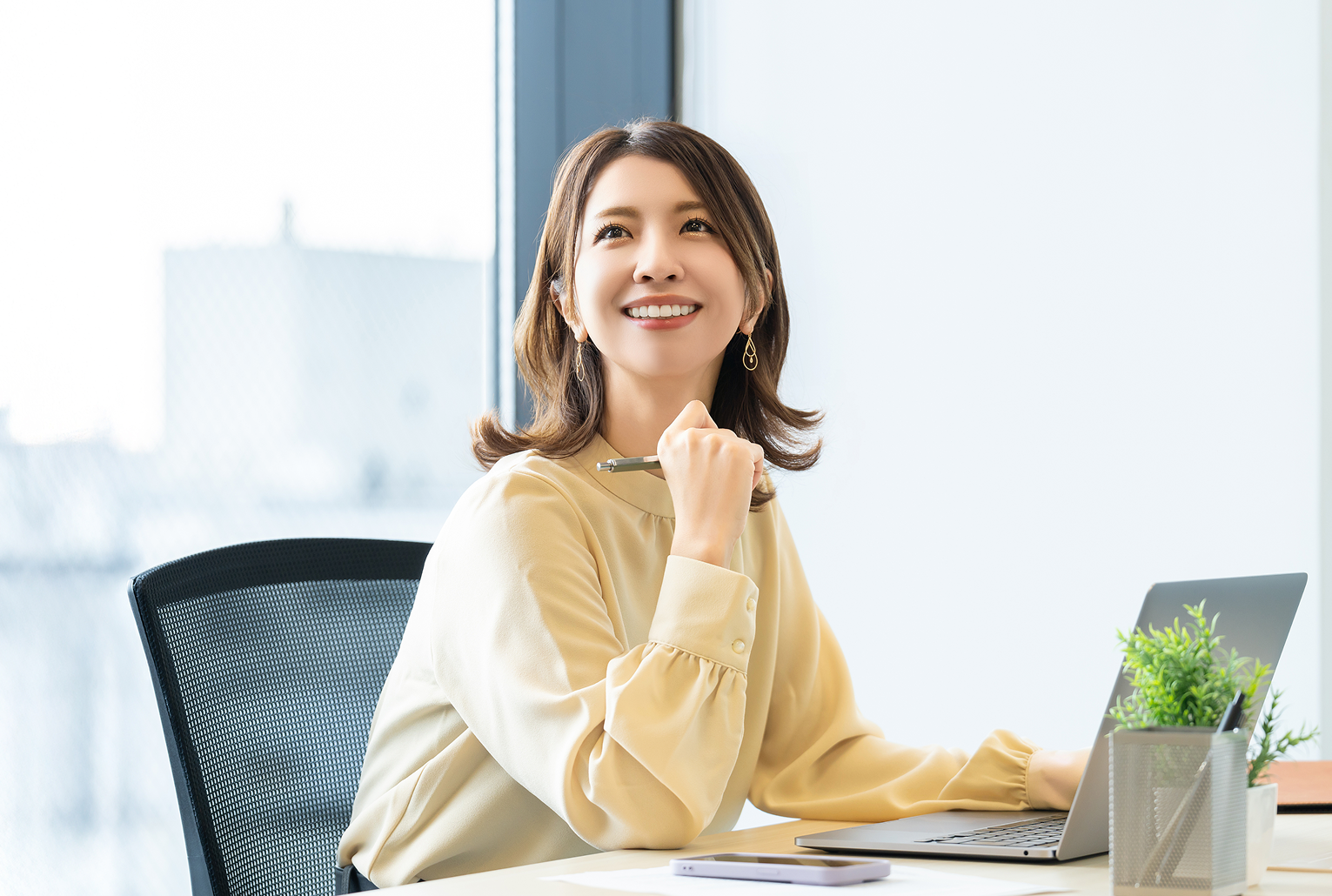 女性が笑顔で仕事をしている様子の写真